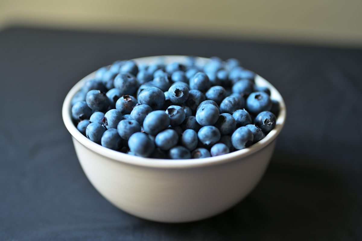 A white bowl filled with fresh blueberries