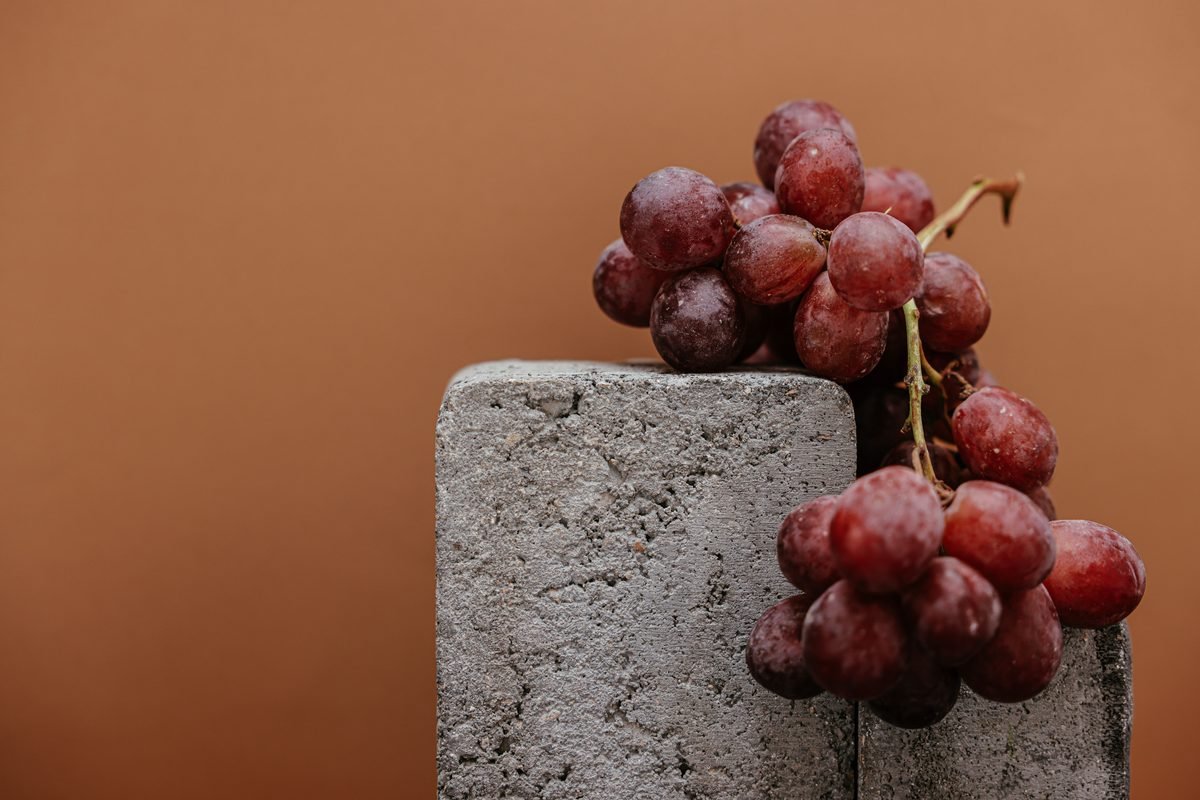 Two bunches of red grapes against a warm background